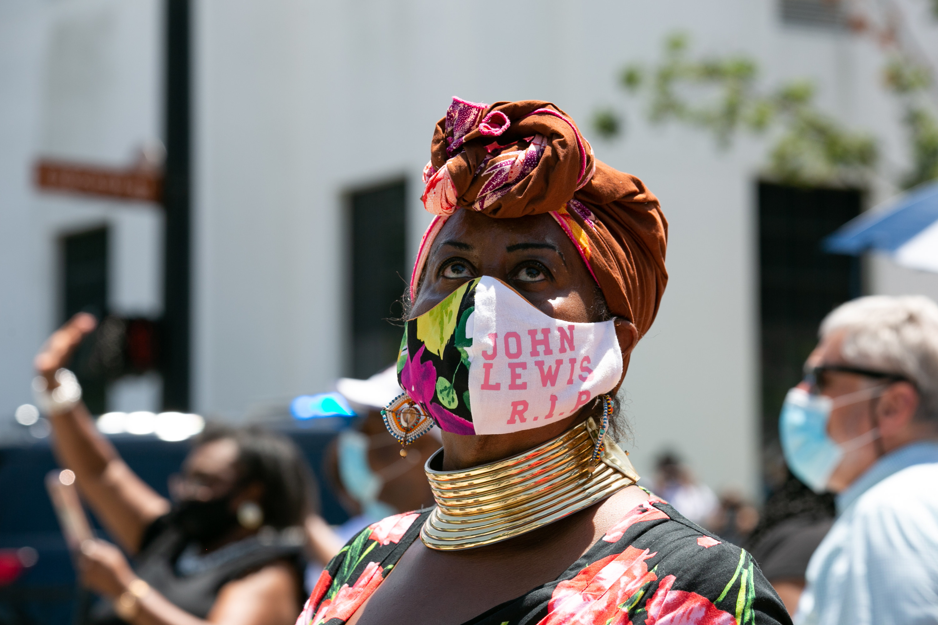 A woman wears a mask that says &quot;John Lewis RIP&quot;