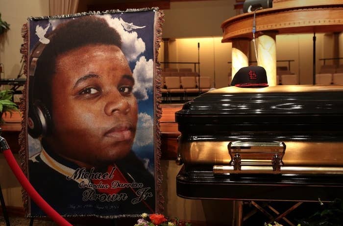 A large poster of Michael Brown sits next to his casket, which has a St Louis Cardinals cap placed on top