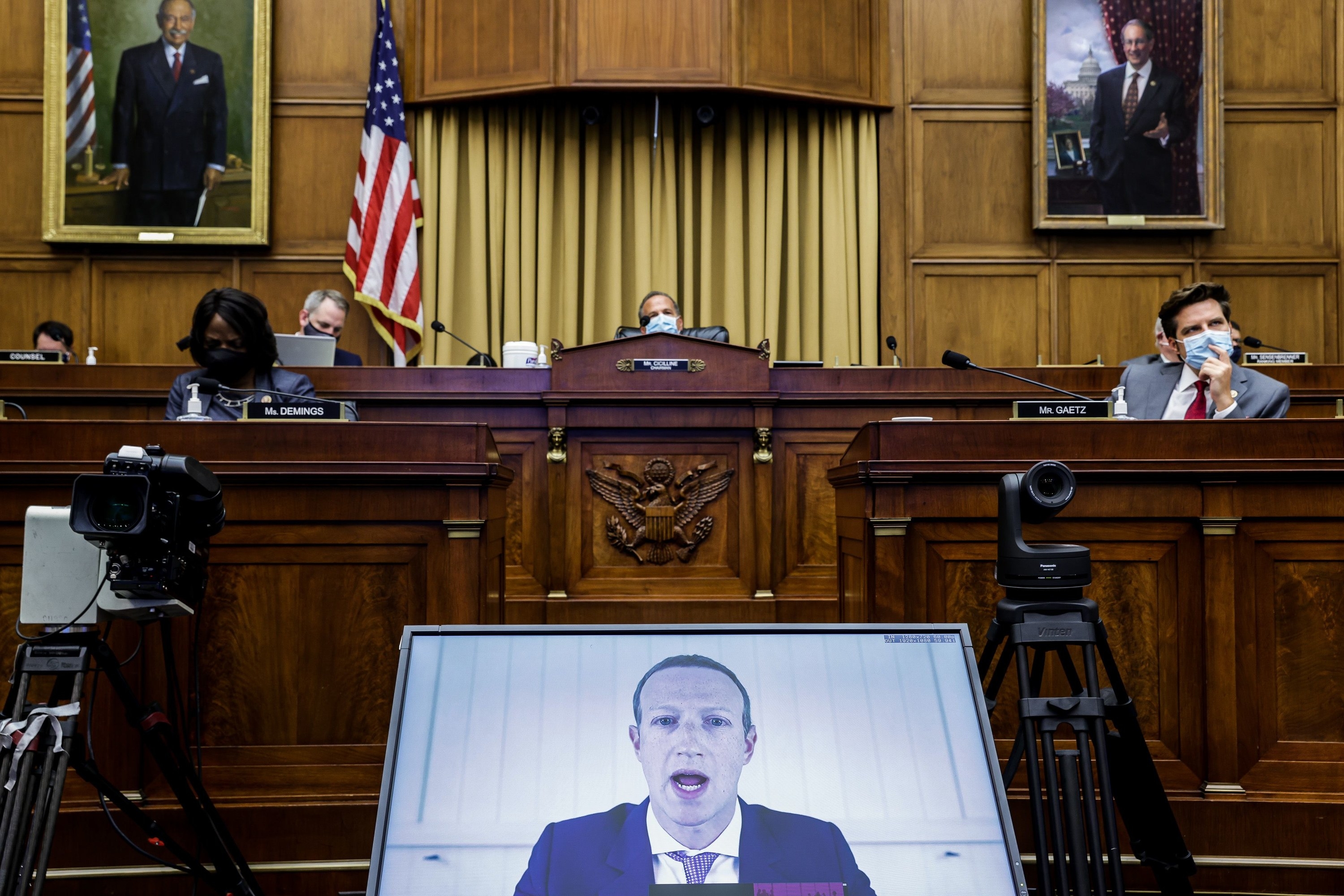 Mark Zuckerberg appears in a screen at the bottom; above, members of the House subcommittee sit and listen