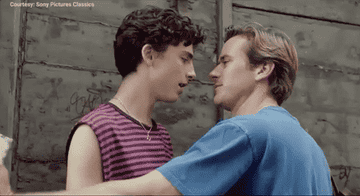 Oliver leaning in close to Elio in a flirtatious way. 