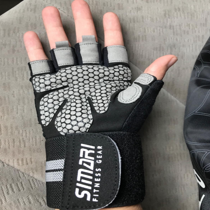 A reviewer shows the palm side of the gray gloves