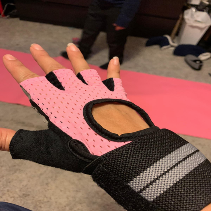A reviewer shows the back side of the pink gloves