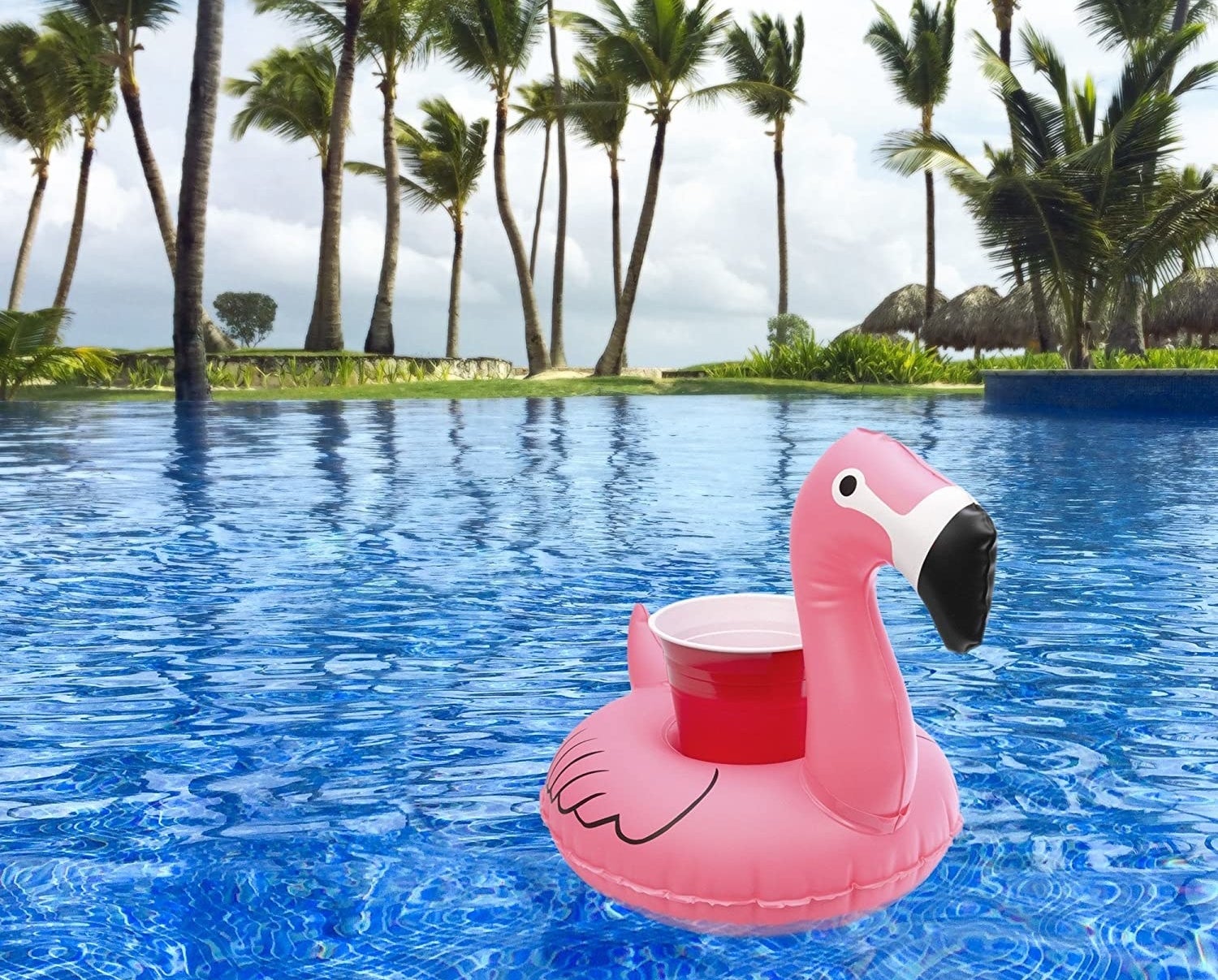 The flamingo drink float holding a red cup in a pool