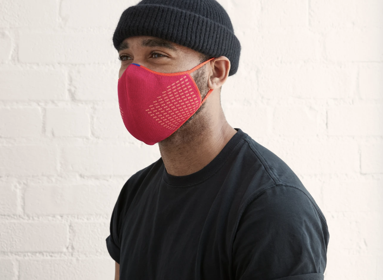 A model in a pink face mask with orange detailing