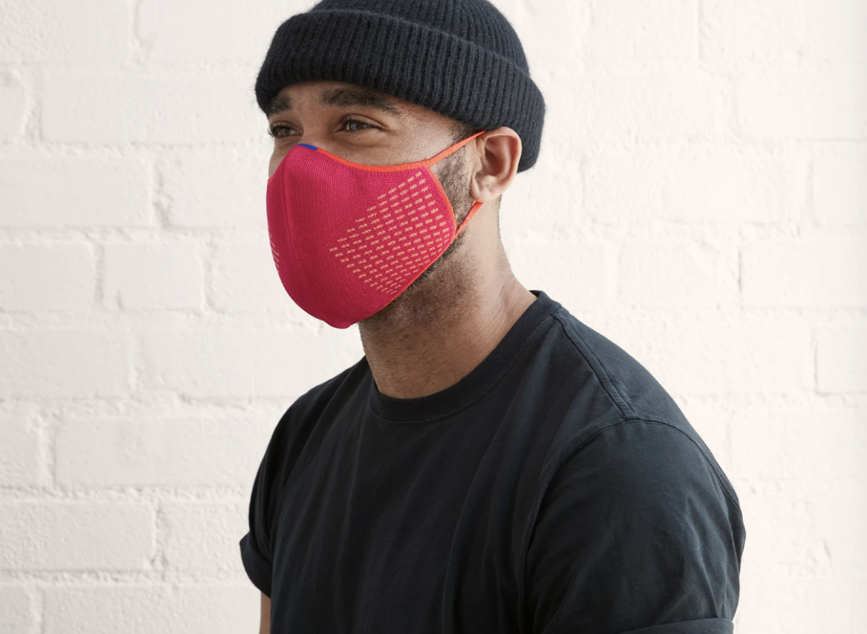 A model in a pink face mask with orange detailing 