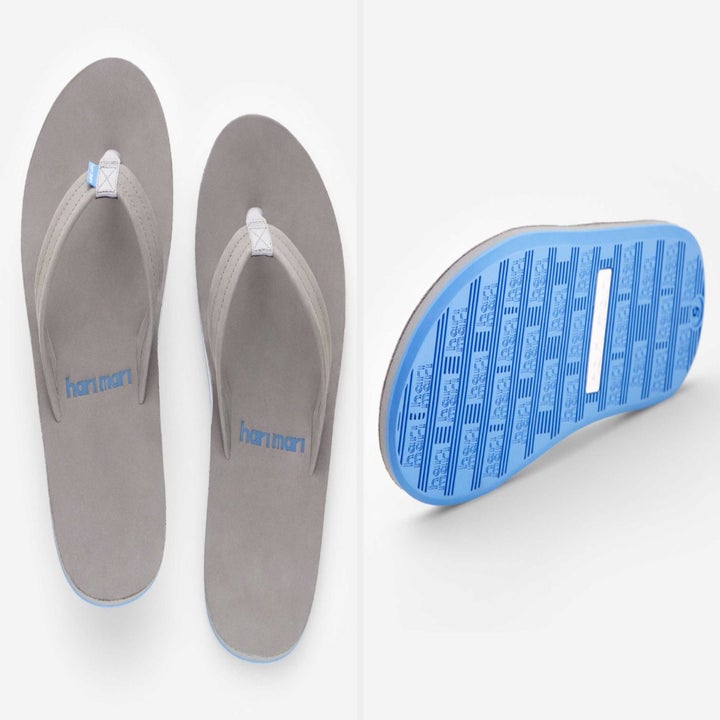 A top-down view of light gray sandals and view of their blue soles 