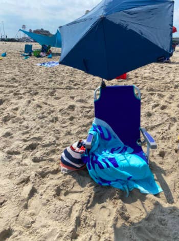 Reviewer uses same adjustable umbrella over their beach chair to get shade from the sun