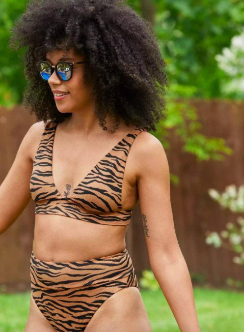 Model wears tiger-printed adjustable bikini top with matching high-waist bottoms