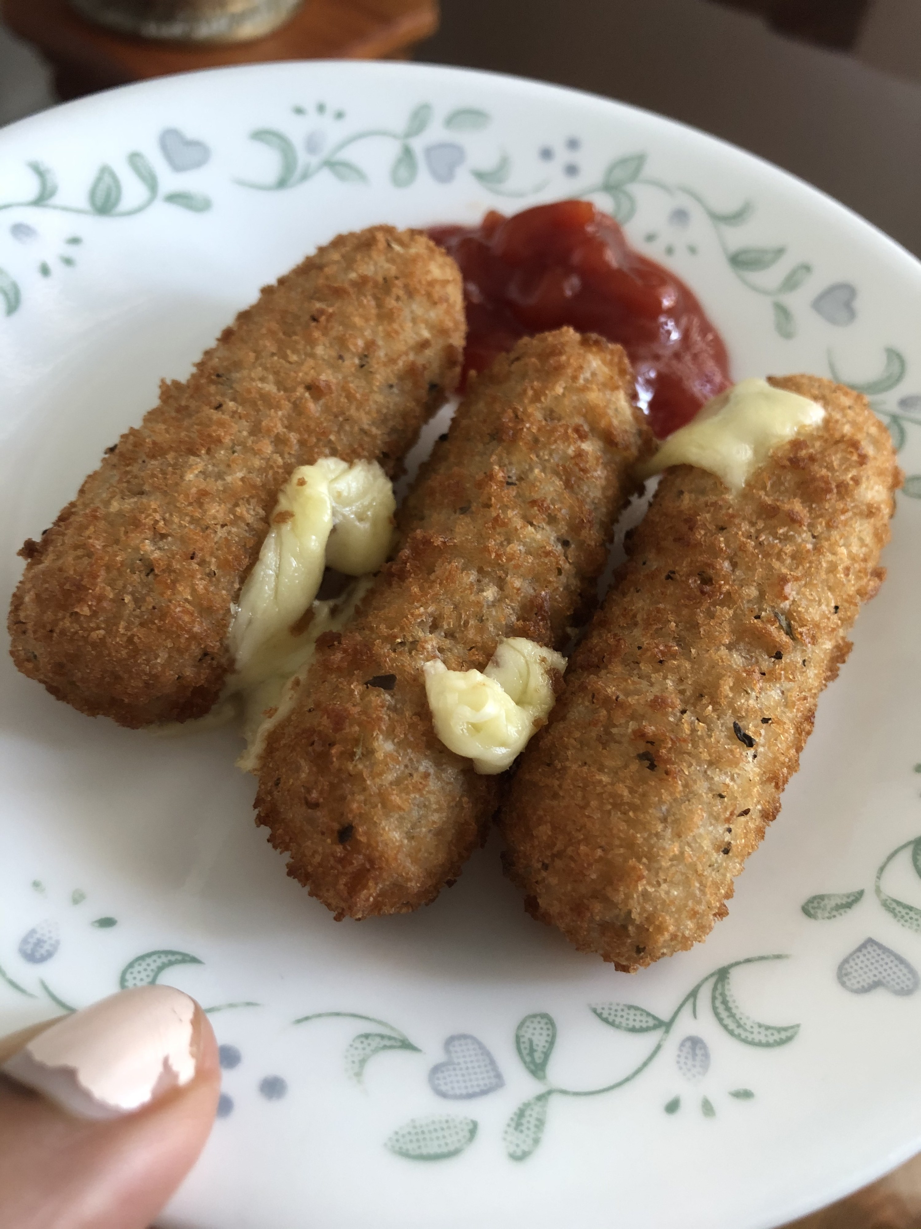 Mozzarella sticks on a plate with cheese gushing out of them