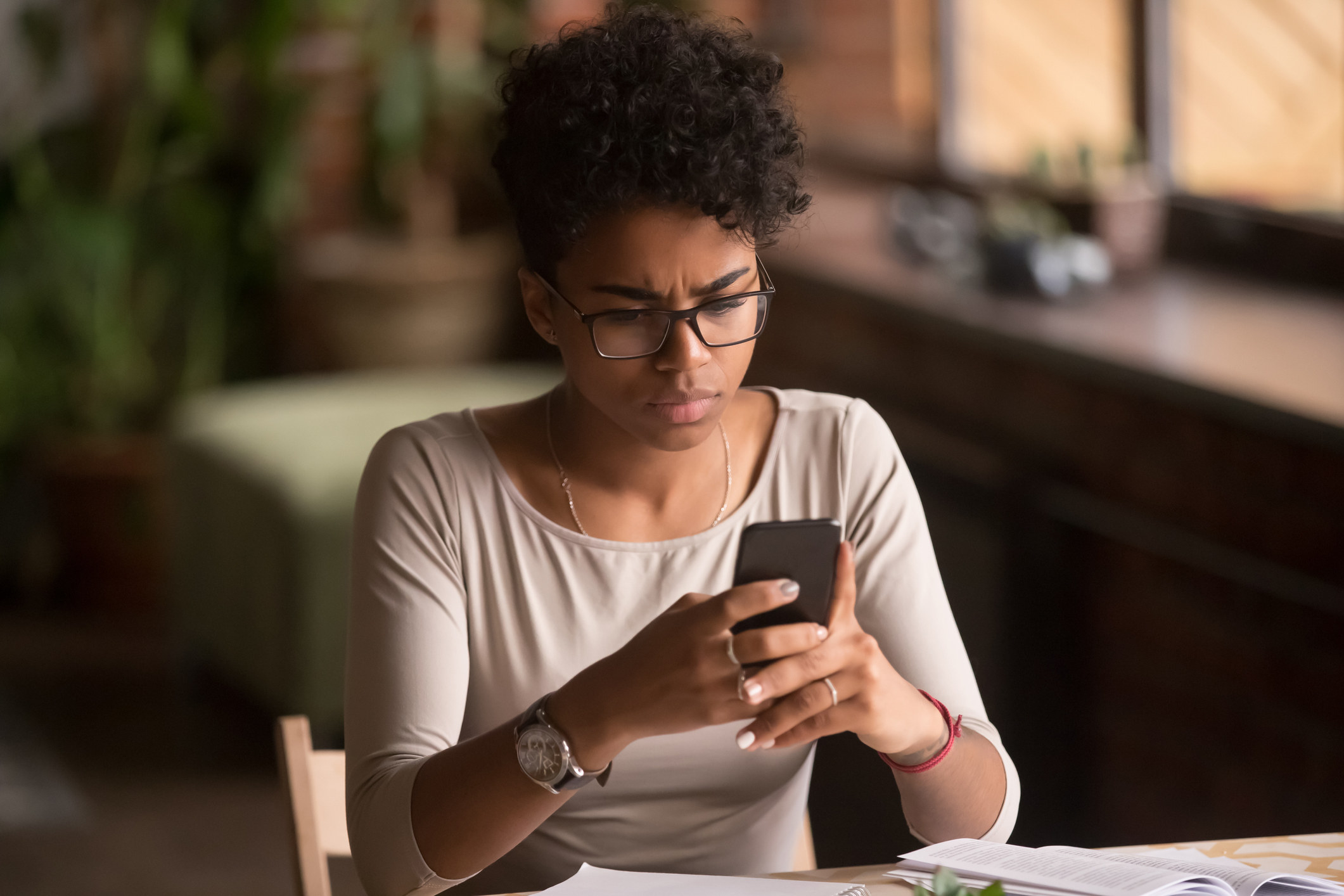 A woman scrolling through a phone, distraught