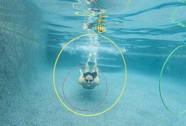 A model underwater about to swim through the rings