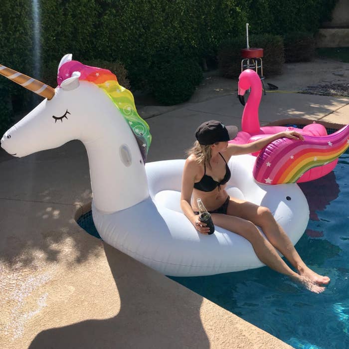 A reviewer sitting up on the unicorn floatie, which is solid and has no hole