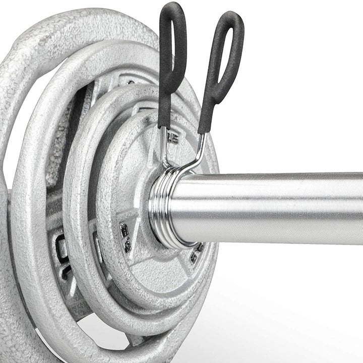 A spring clip on the end of a bar holding dumbbells in place
