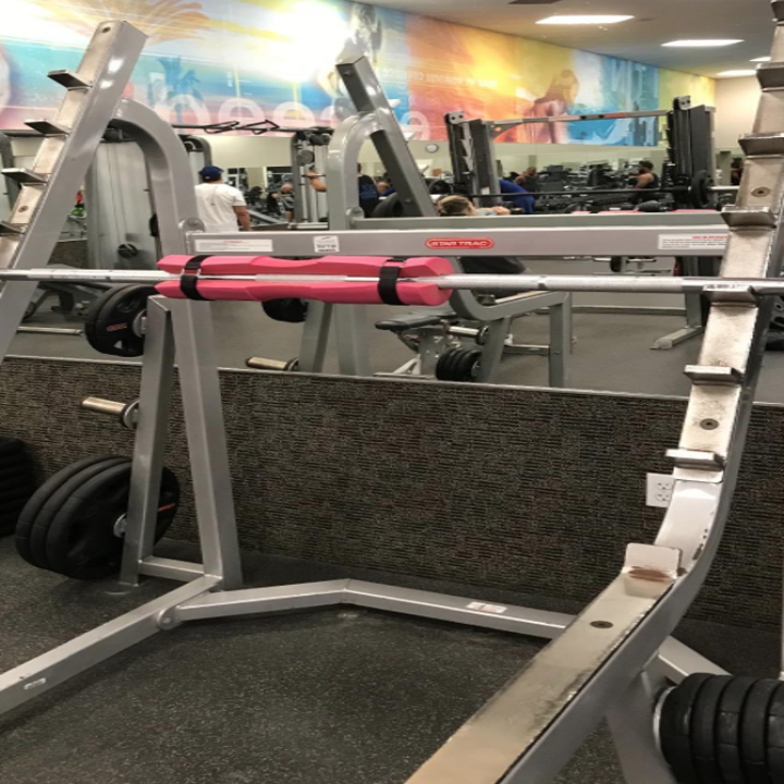 A reviewer's squat pad attached and strapped onto a barbell