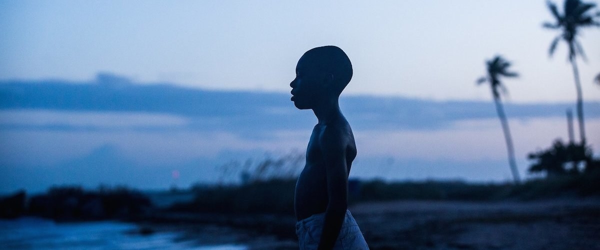 A young boy in &quot;Moonlight&quot; stands on the beach as the sun sets.