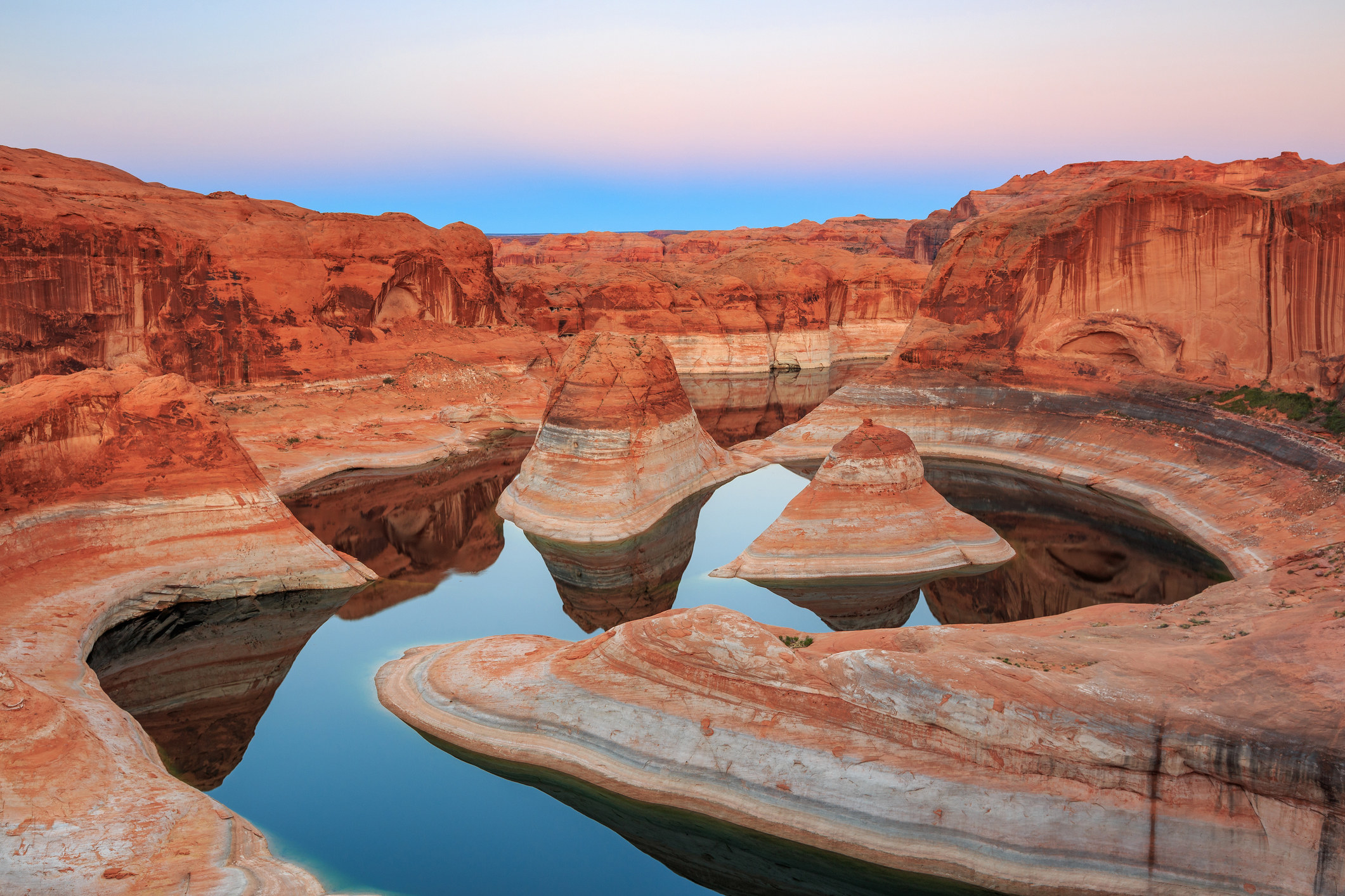 Dusk sky above a red canyon being reflected in waters of Lake Powell