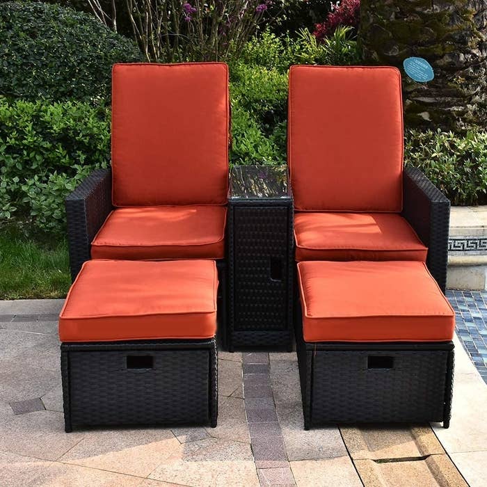 high-back chairs with ottomans with bright orange cushions