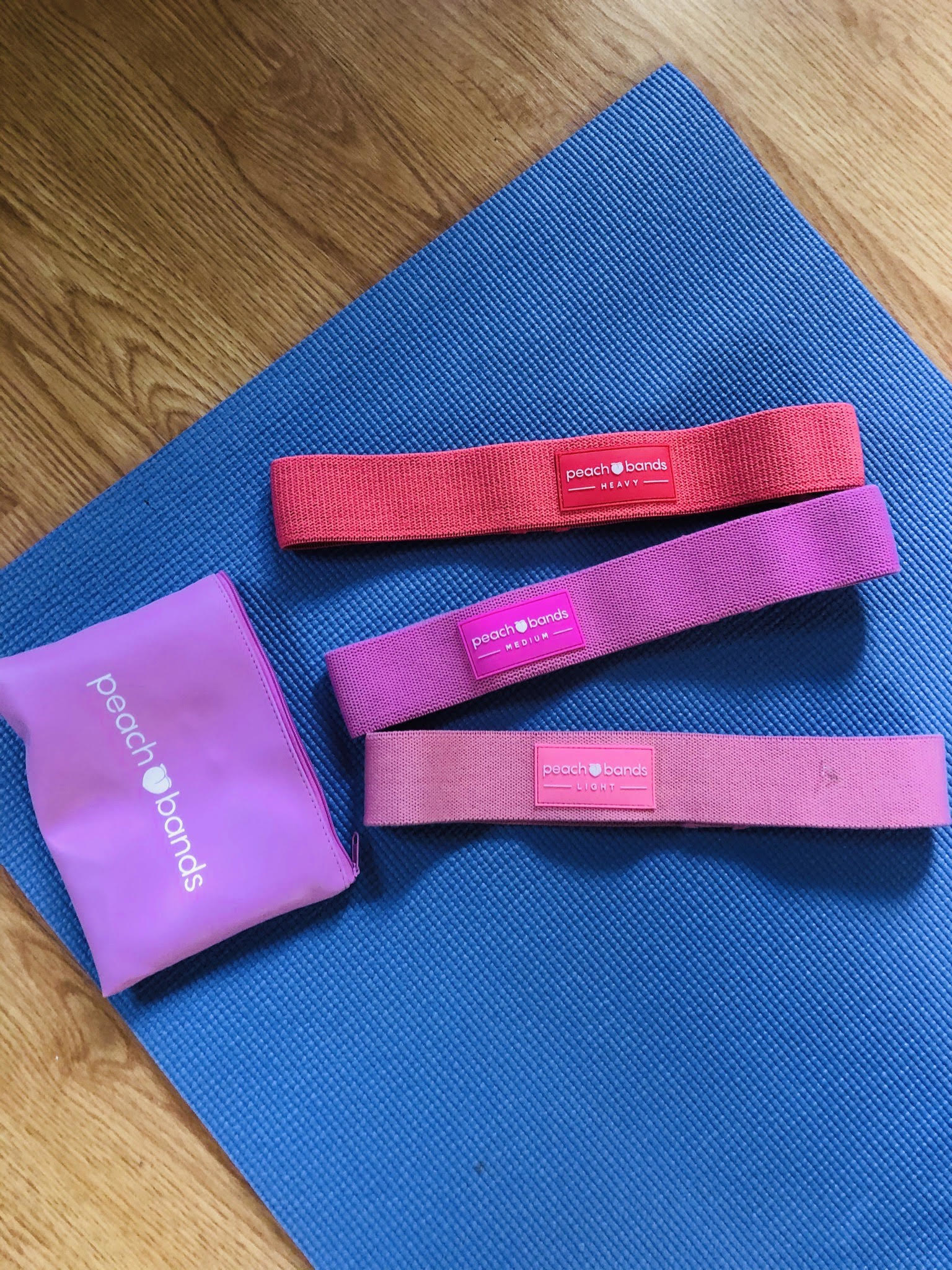 The set of three peach bands lying on a workout mat