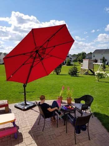 reviewer's umbrella tilted upward for maximum shade over patio