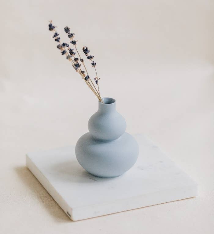 Small double gourd mini vase in blue with a couple of strands of dried flowers in it