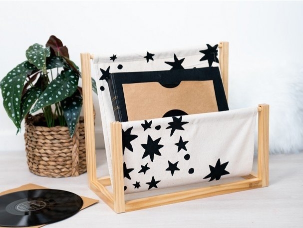 A light wooden book holder with a white canvas covered in black stars