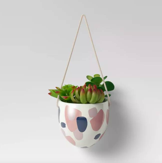 A drip hanging planter with a white, pink, and navy blue shape pattern
