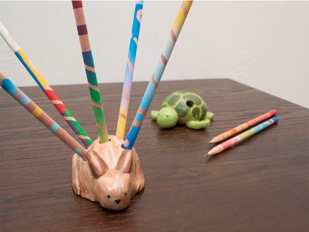 A brown rabbit with holes for pencils and a green turtle pencil holder