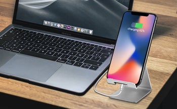 The phone holder propping up a phone screen on a desk 