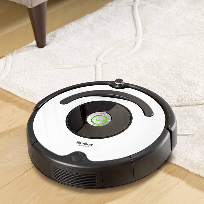A white circular Roomba with black edges 