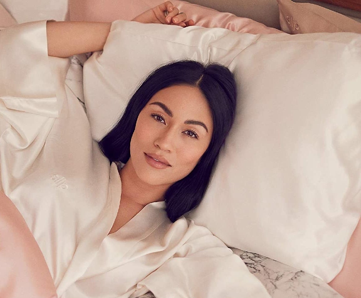 model laying on white silk pillowcase