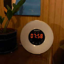 The same reviewer's clock display looking much dimmer with a sticker on 