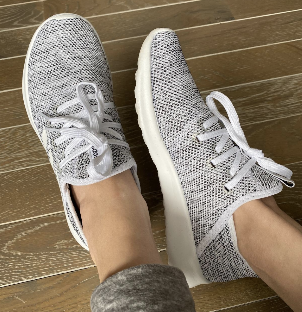 reviewer wearing white and gray lace-up sneakers