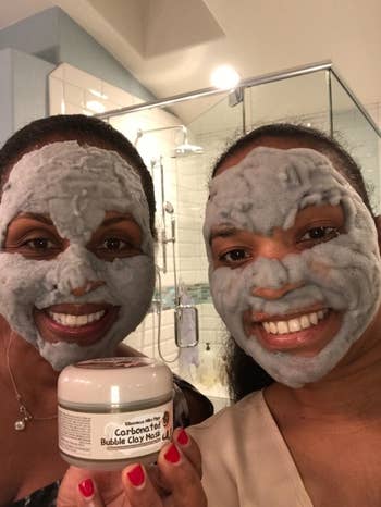 two reviewers pose with the jar and foaming mask on faces