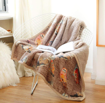 A brown throw blanket printed with owls on a wired chair