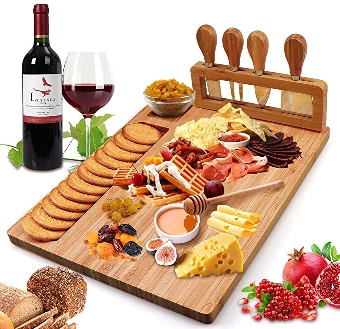 A cheese board with cheese, meat, crackers, dips and fruit on it