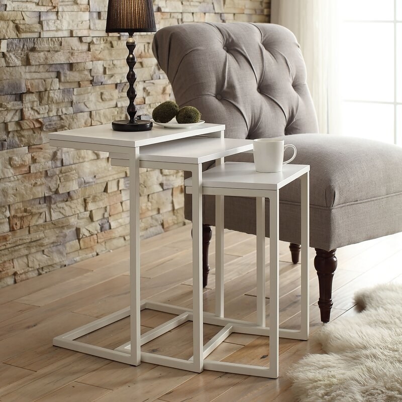 White nesting tables tucked within each other in size descending order