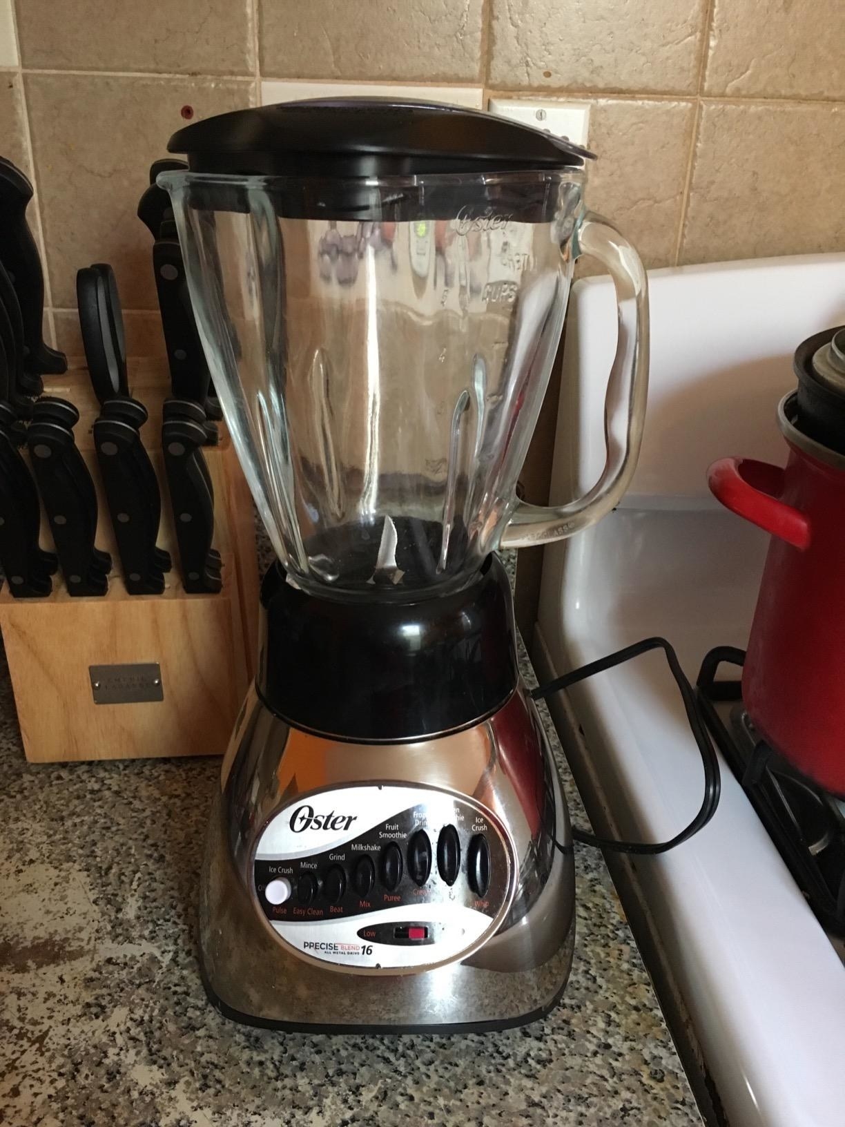 A reviewer&#x27;s photo of a shiny silver blender with black accents at the top and bottom of the jar
