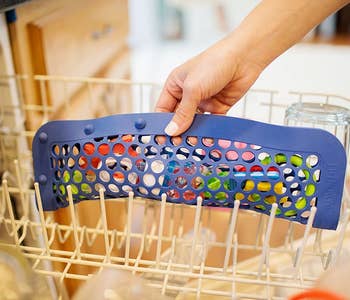 The same hand putting the product in a dishwasher, this time closed horizontally