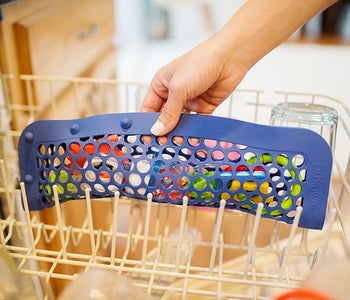 The same hand putting the product in a dishwasher, this time closed horizontally
