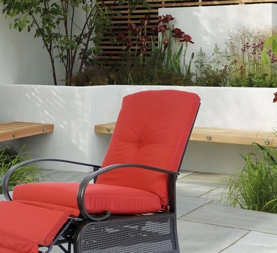 red cushioned recliner with black metal frame on patio