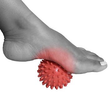 A model's foot on top of the spiky massage ball 