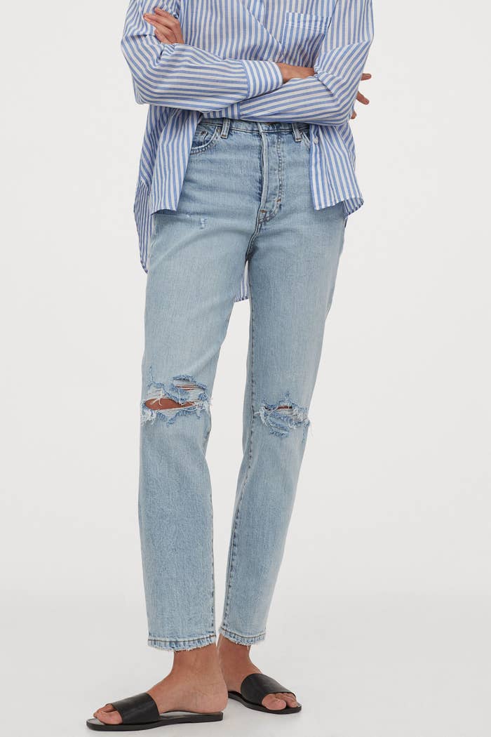 Model in the straight-leg jeans with small knee holes 