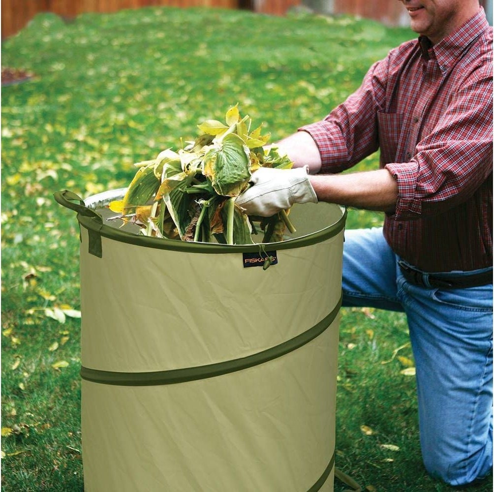 A model putting leaves into the collapsible gardening container 