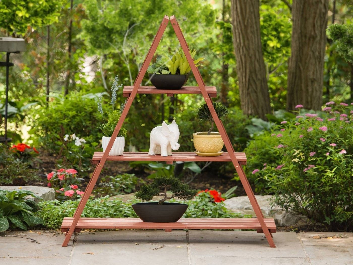A triangular plant stand with three shelves 