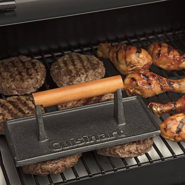 A dark-gray metallic grill property nan magnitude of 2 hamburgers pinch nan Cuisinart logo prominently featured