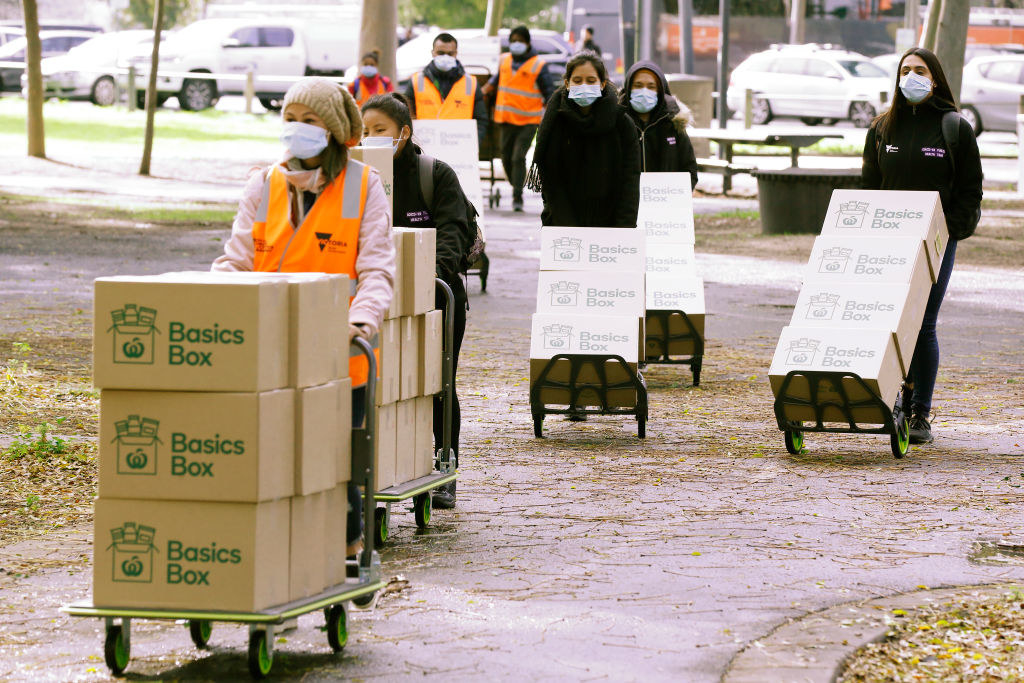 Boxes of food being delivered by volunteers wearing masks