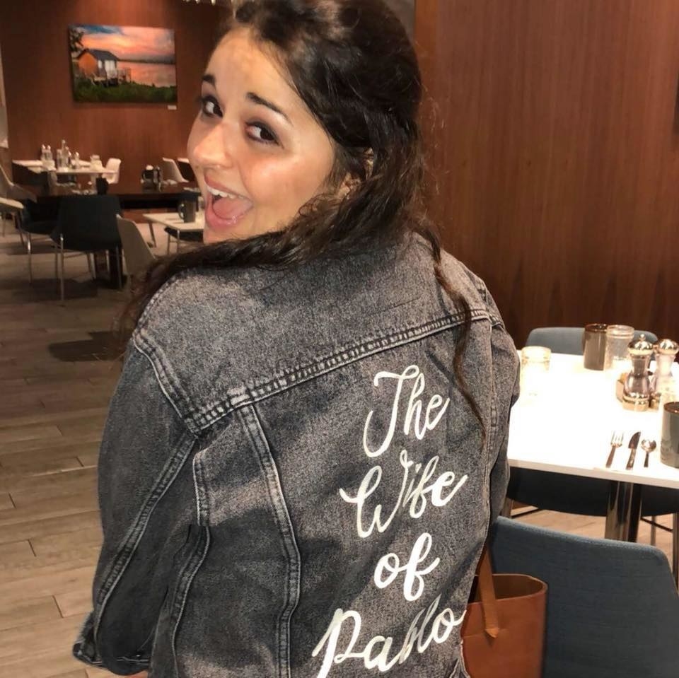 buzzfeed editor wearing a grey denim jacket, the back says &quot;the wife of pablo&quot; in white embroidery