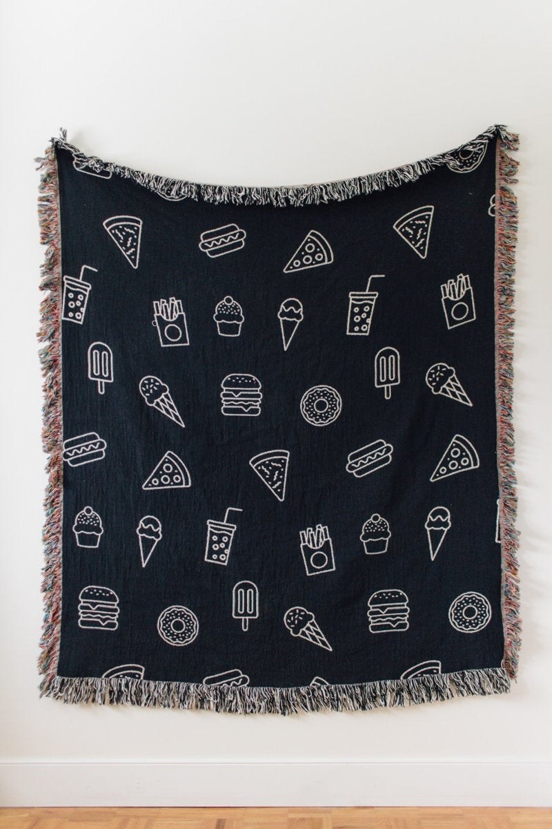 a black blanket with various foods on it in white stitching with various colored fringe edges