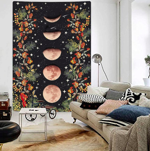 A black tapestry with multicolored florals and a pink phases of the moon graphic