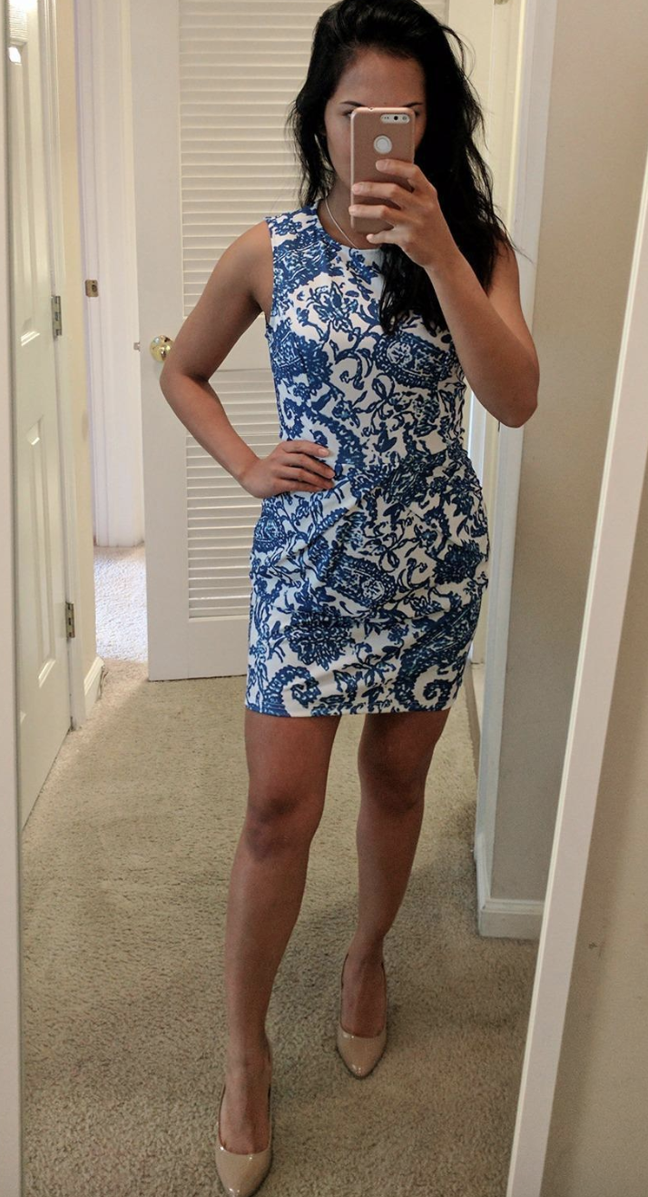 reviewer wears white mini dress with blue pattern of paisley and flowers 